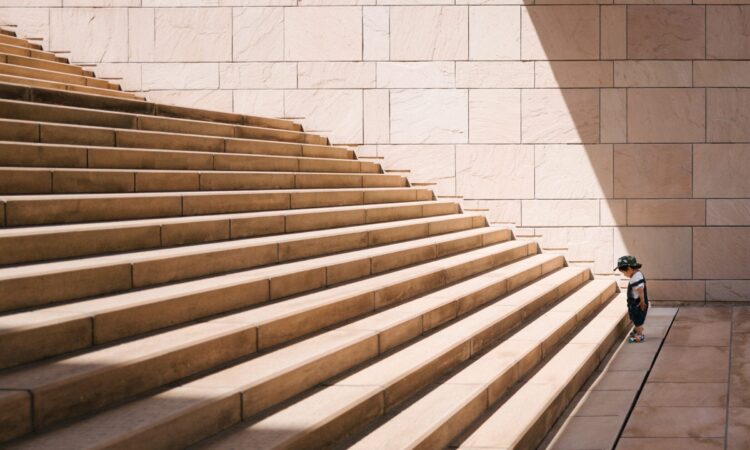 toddler's standing in front of beige concrete stair